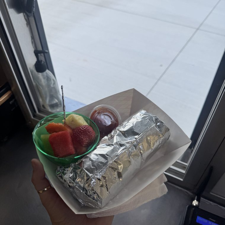 A burrito and a fruit cup to go