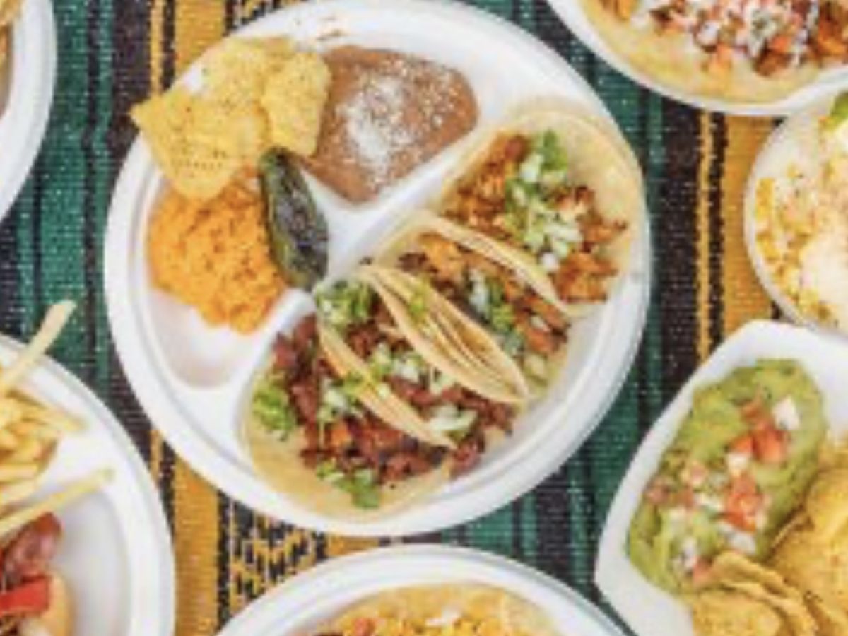 An overhead spread of tacos, quesadillas, fries and elote
